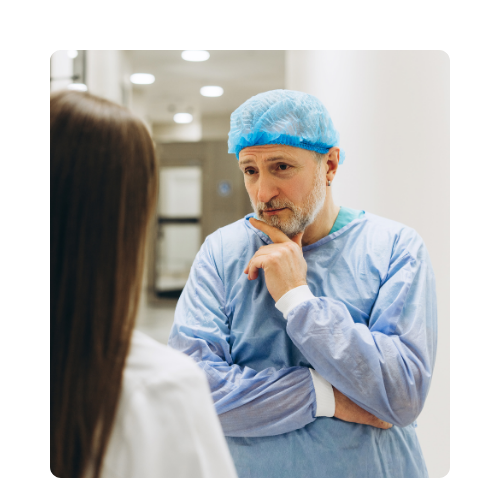 Chirurg w stroju operacyjnym rozmawiający z pacjentką na korytarzu