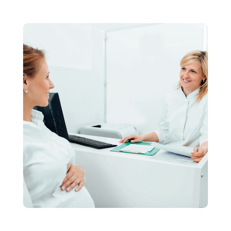 Kobieta w ciąży podczas konsultacji z lekarką w gabinecie lekarskim