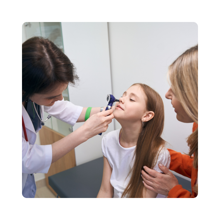 Lekarka wykonująca badanie nosa u dziewczynki w obecności opiekunki
