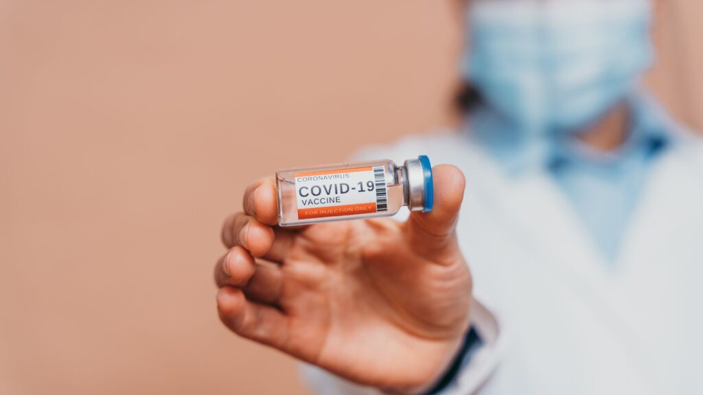 Lekarz trzyma fiolkę ze szczepionką przeciw COVID-19