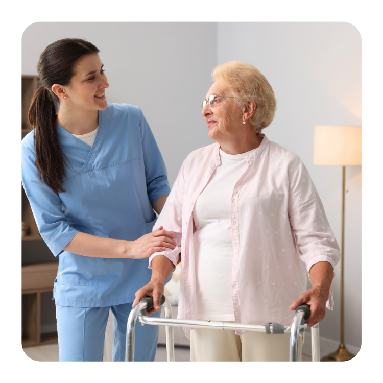 zdjęcia na główną stronę poradni na dubiela (3) Pielęgniarka wspiera starszą kobietę korzystającą z balkonika podczas wizyty domowej w ramach opieki długoterminowej.